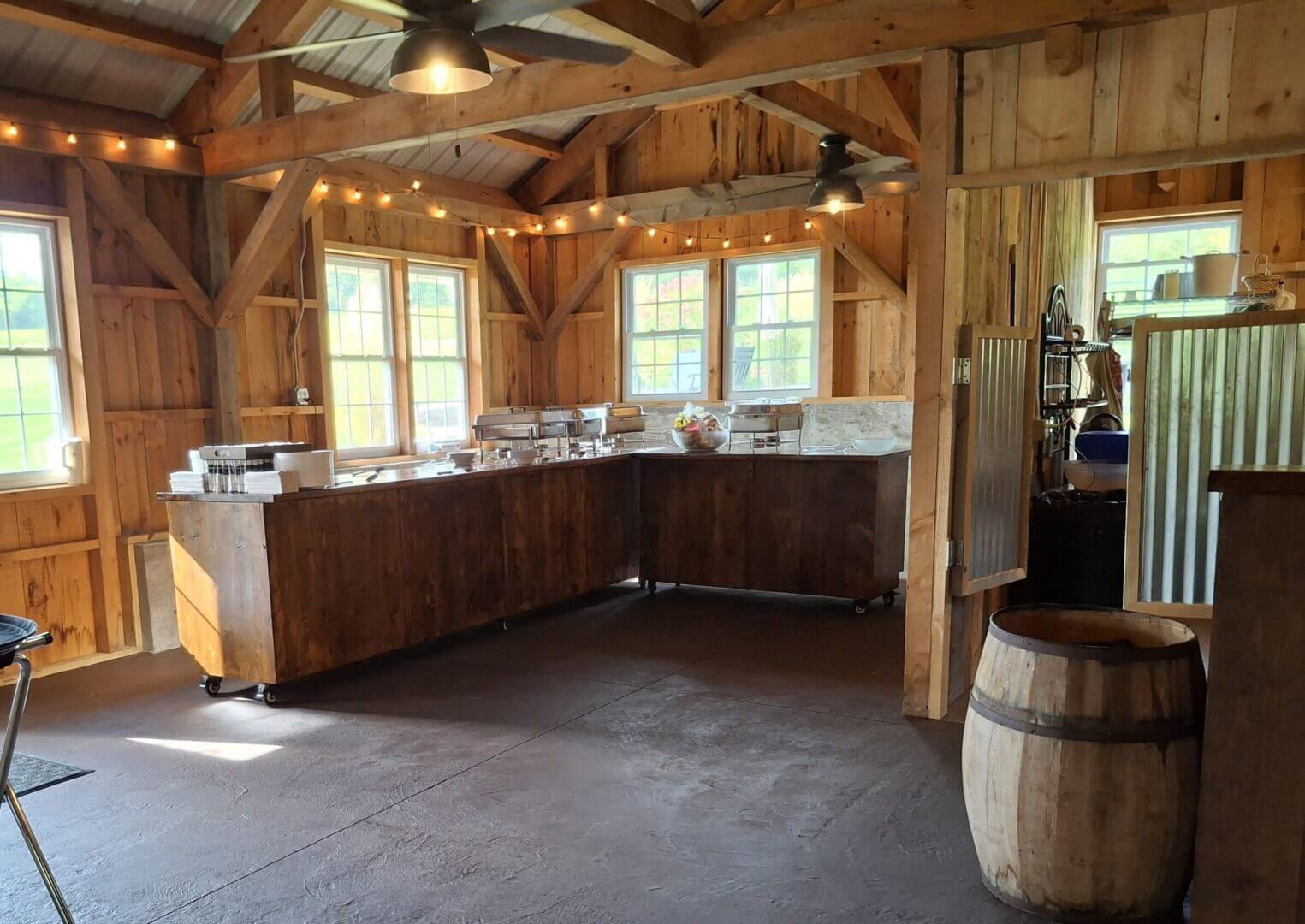 Rustic kitchen with wooden beams and large windows.
